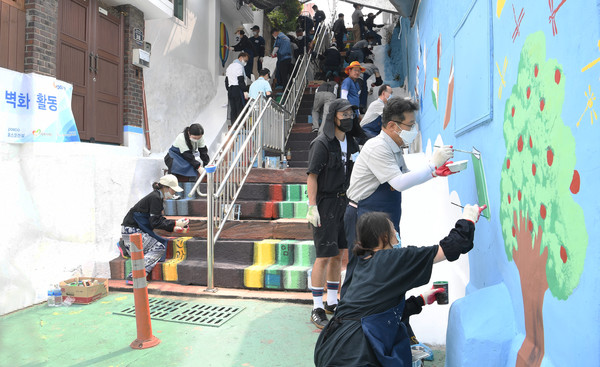 포스코건설 임직원들이 배다리 마을 벽화 그리기 봉사활동을 벌이고 있다.<사진=포스코건설>