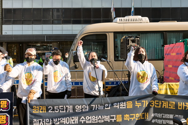 함께하는 사교육 연합 회원들이 서울 여의도 더불어민주당사 앞에서 코로나19 집합금지 조치를 풀어달라고 요구하고 있다.<사진=함사연측>
